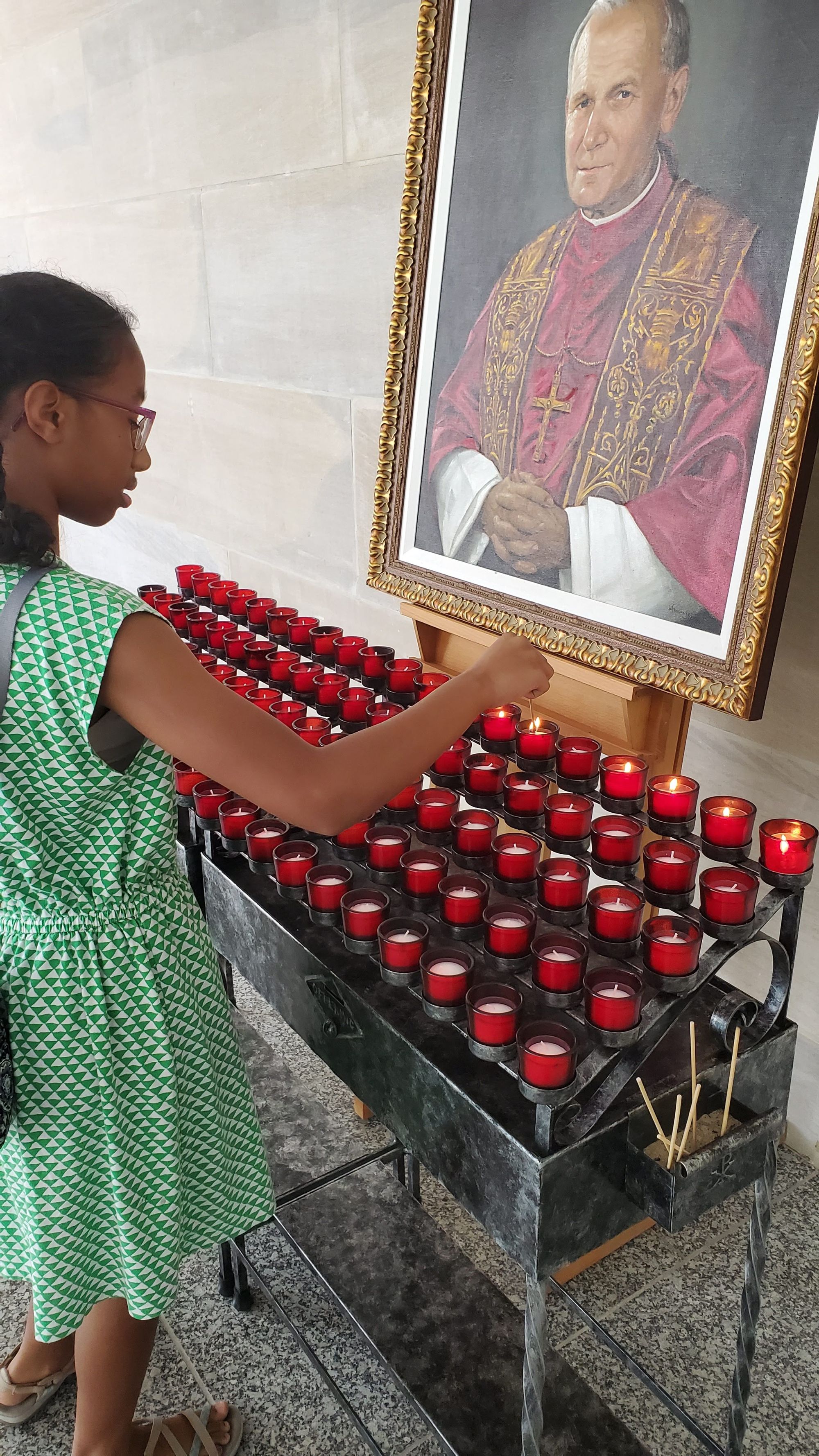 black-girl-lighting-candles-at-john-paul-ii-shrine-from-sdcason-dot-com