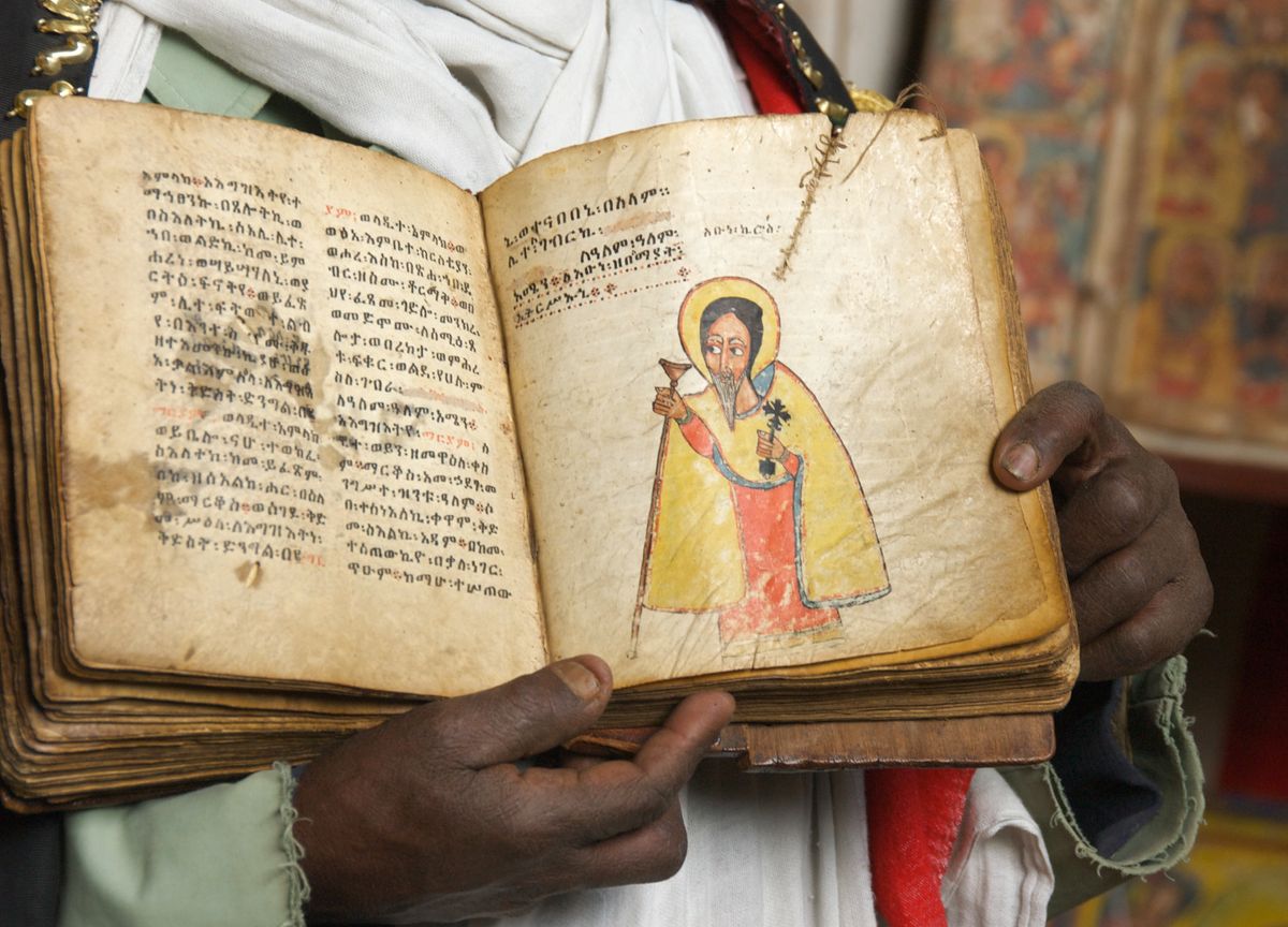 Close-Up of Cleric Displaying Manuscript with Text and Painting at the Monastery of Na’akuto La’ab - Orthodox Stock Photo